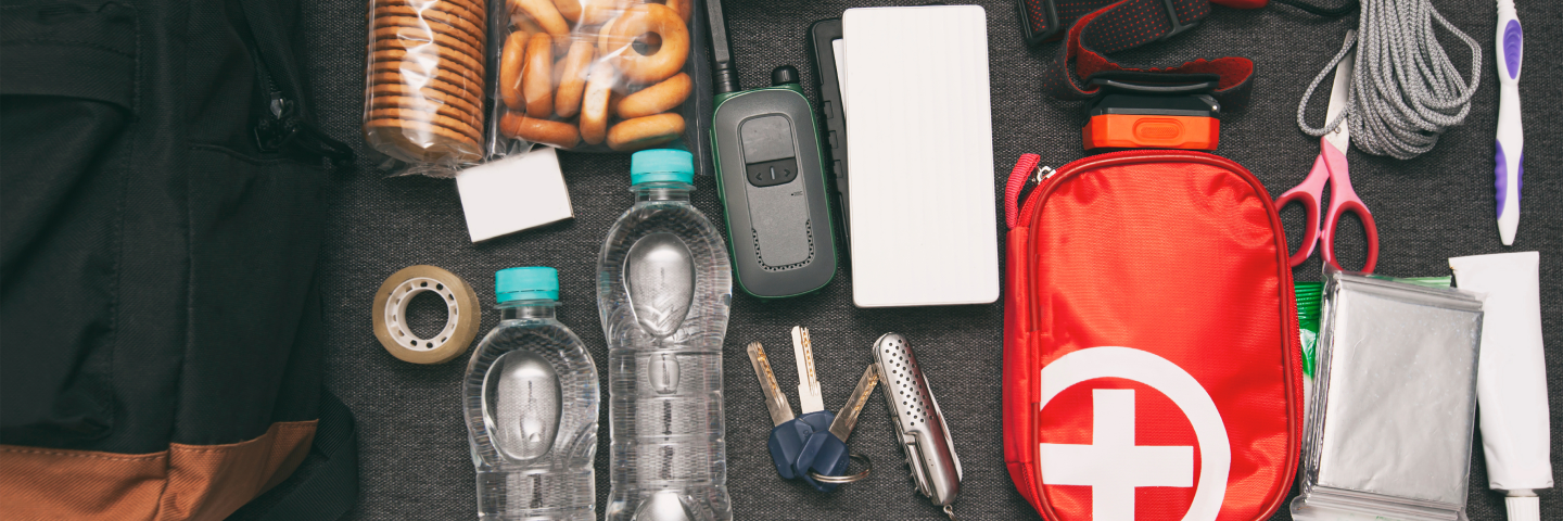 Elements to go into an emergency go bag, including food, water, a first aid kit, scissors and a toothbrush.